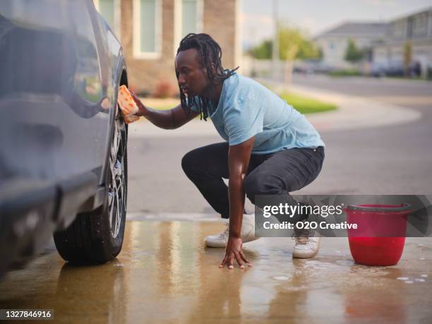 young couple washing a car in a driveway - buying a car stock pictures, royalty-free photos & images