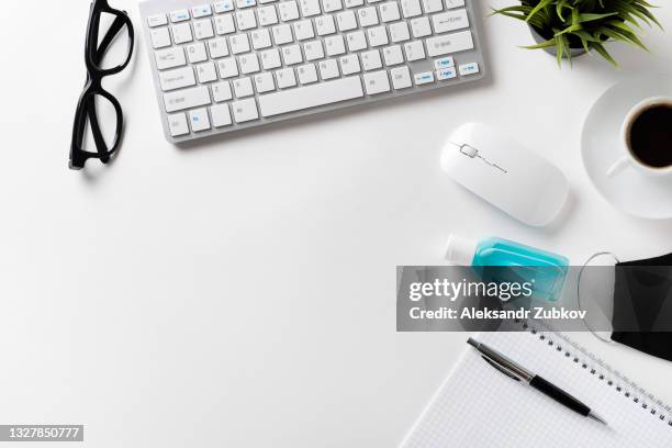 safety and hygiene measures in the office. prevention of the spread of the covid-19 coronavirus epidemic. protective face mask, keyboard, computer mouse, pen and mug with black coffee, hand sanitizer, on the freelancer's desktop or white background. - siberian mouse fotografías e imágenes de stock