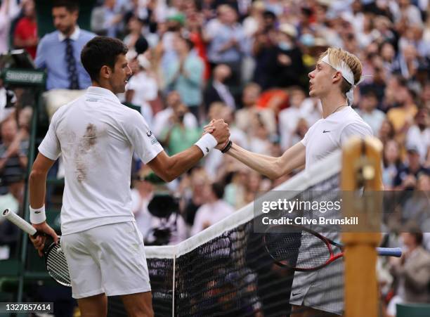 Novak Djokovic of Serbia and Denis Shapovalov of Canada shake hands at the net after their Men's Singles Semi-Final match during Day Eleven of The...