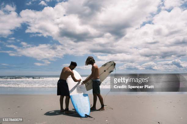 Surfers take advantage of unusually high surf due to Tropical Storm Elsa at Rockaway Beach in Queens on July 09, 2021 in New York City. After coming...