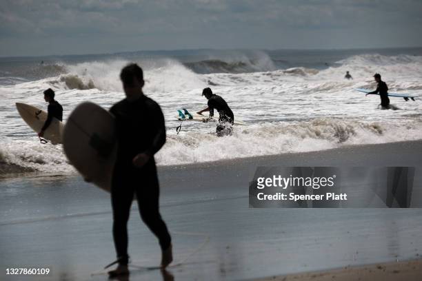 Surfers take advantage of unusually high surf due to Tropical Storm Elsa at Rockaway Beach in Queens on July 09, 2021 in New York City. After coming...