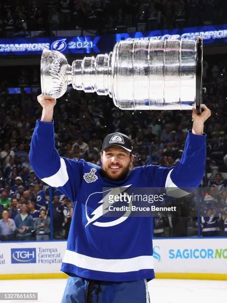 Luke Schenn of the Tampa Bay Lightning celebrates with the Stanley Cup following the victory over the Montreal Canadiens in Game Five of the 2021 NHL...