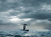 Man With An Umbrella Stranded On A  Boat