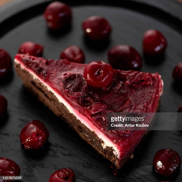 slice of chocolate cherry cake on black tray. romantic dessert. top side view. soft focus. close-up shot - chocolate top view stock-fotos und bilder