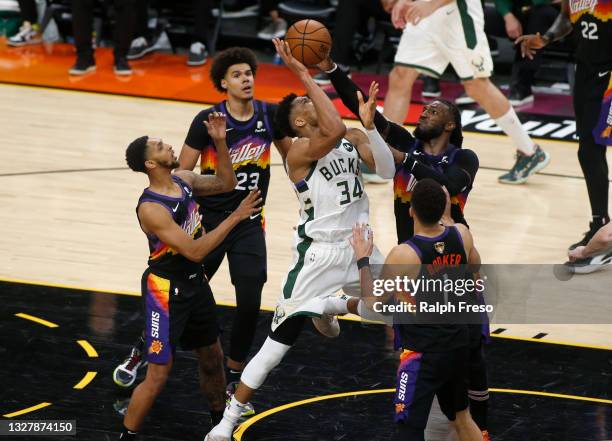 Giannis Antetokounmpo of the Milwaukee Bucks attempts to drive to the basket between Cam Johnson, Cameron Payne, Jae Crowder and Devin Booker of the...