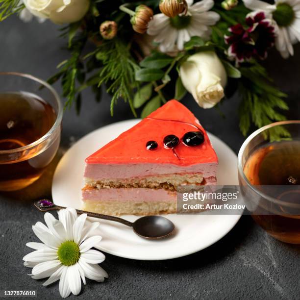 romantic dessert. slice of red cake on saucer, two cups of tea and bouquet of flowers on table. top side view. soft focus - lob wedge stock-fotos und bilder