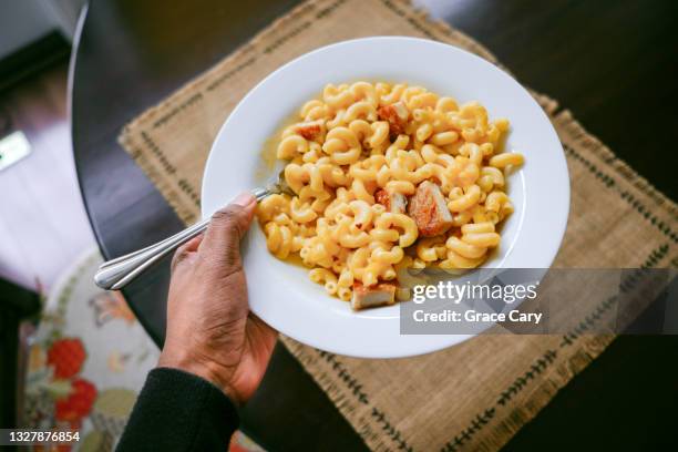 woman carries macaroni and cheese dish - macaroni and cheese stockfoto's en -beelden