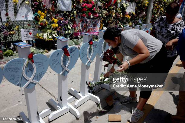 Celine Churchman, a high school student with the organization "7 Helping Hands" puts flowers at the memorial site for the victims of the collapsed...