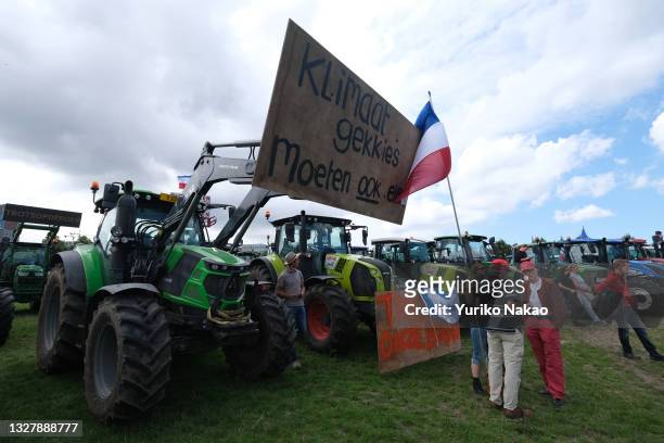 Dutch farmers with their tractors attend a rally protesting against the government's plans to reduce nitrogen emissions in the country on July 7,...