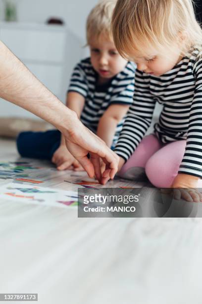 father teaching children to play puzzle - three storey stock pictures, royalty-free photos & images