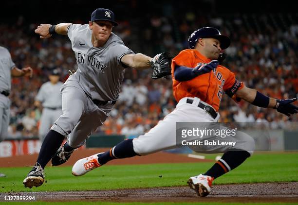 Jose Altuve of the Houston Astros runs out of the baseline to avoid the tag by DJ LeMahieu of the New York Yankees in the first inning at Minute Maid...