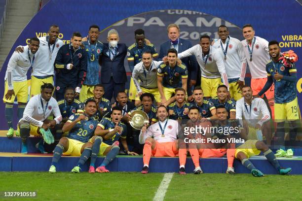 Juan Cuadrado and David Ospina of Colombia pose with the third place trophy after winning a Third Place play off match between Peru and Colombia as...