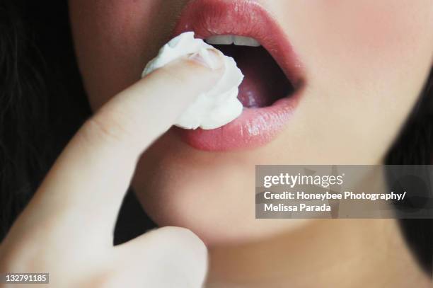 woman licking cream - aufschäumen stock-fotos und bilder