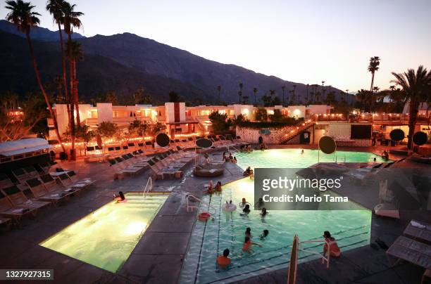 People gather in a hotel pool after sunset in triple digit heat on July 09, 2021 in Palm Springs, California. ‘Dangerously hot conditions’ are...