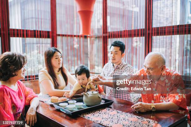 chinese multi generation enjoying traditional mid-autumn mooncake and chinese tea at home during afternoon tea gathering - mooncake stock pictures, royalty-free photos & images