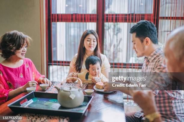 chinese multi generation enjoying traditional mid-autumn mooncake and chinese tea at home during afternoon tea gathering - lantern festival stock pictures, royalty-free photos & images