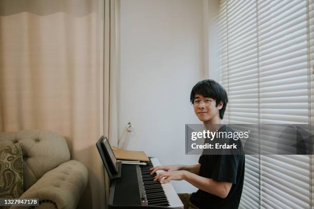 nerd young boy look at camera before start his music performance - stock photo - pianist portrait stock pictures, royalty-free photos & images