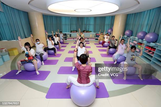 Pregnant women work out with yoga balls during a fitness class at Shijiazhuang Obstetrics and Gynecology Hospital before World Population Day on July...