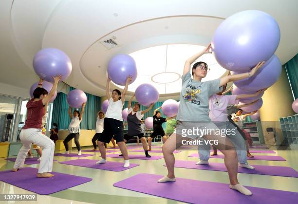 Pregnant women work out with yoga balls during a fitness class at Shijiazhuang Obstetrics and Gynecology Hospital before World Population Day on July...