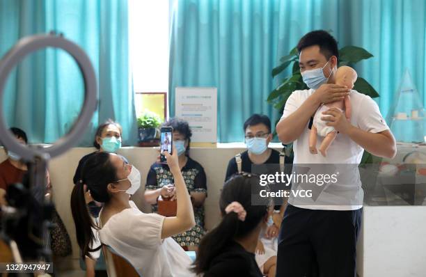 Father-to-be learns to take care of newborns at Shijiazhuang Obstetrics and Gynecology Hospital before World Population Day on July 10, 2021 in...