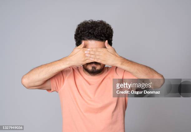man covering his eyes, see no evil, studio shot - hands covering eyes stock pictures, royalty-free photos & images