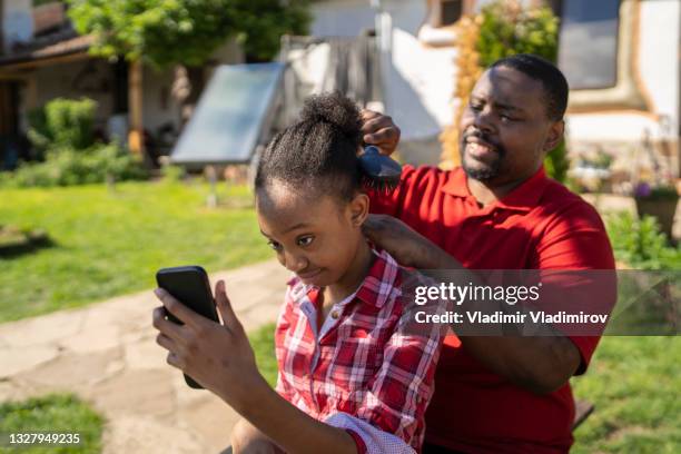 watching dad brushing hair by using a mobile - cell cultures stock pictures, royalty-free photos & images