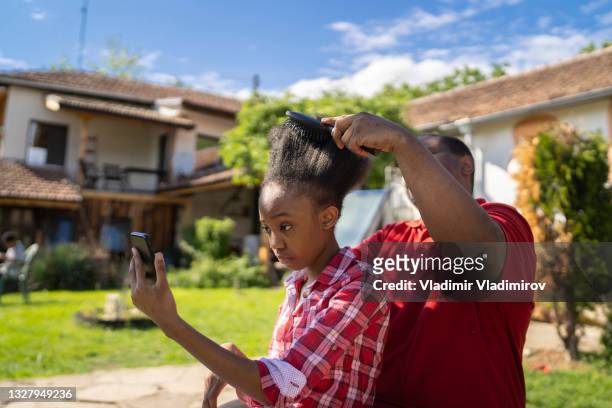 wunschmutter bürstete ihre haare - afro caribbean and american stock-fotos und bilder