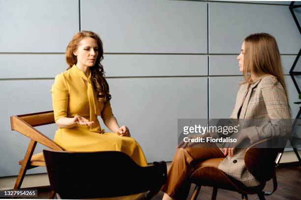 two business women talking in the office - two women talking stockfoto's en -beelden