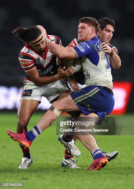 Dylan Napa of the Bulldogs is tackled during the round 17 NRL match between the Canterbury Bulldogs and the Sydney Roosters at Bankwest Stadium, on...