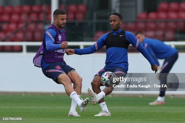 Kyle Walker of England in action with teammate Raheem Sterling during the England Training Session at St George's Park on July 10, 2021 in Burton...