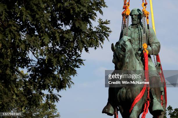 Workers remove a statue of Confederate General Robert E. Lee from Market Street Park July 10, 2021 in Charlottesville, Virginia. Initial plans to...