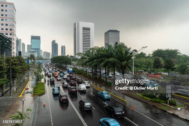 main road through the jakarta modern business district after rain - 新興国 ストックフォトと画像