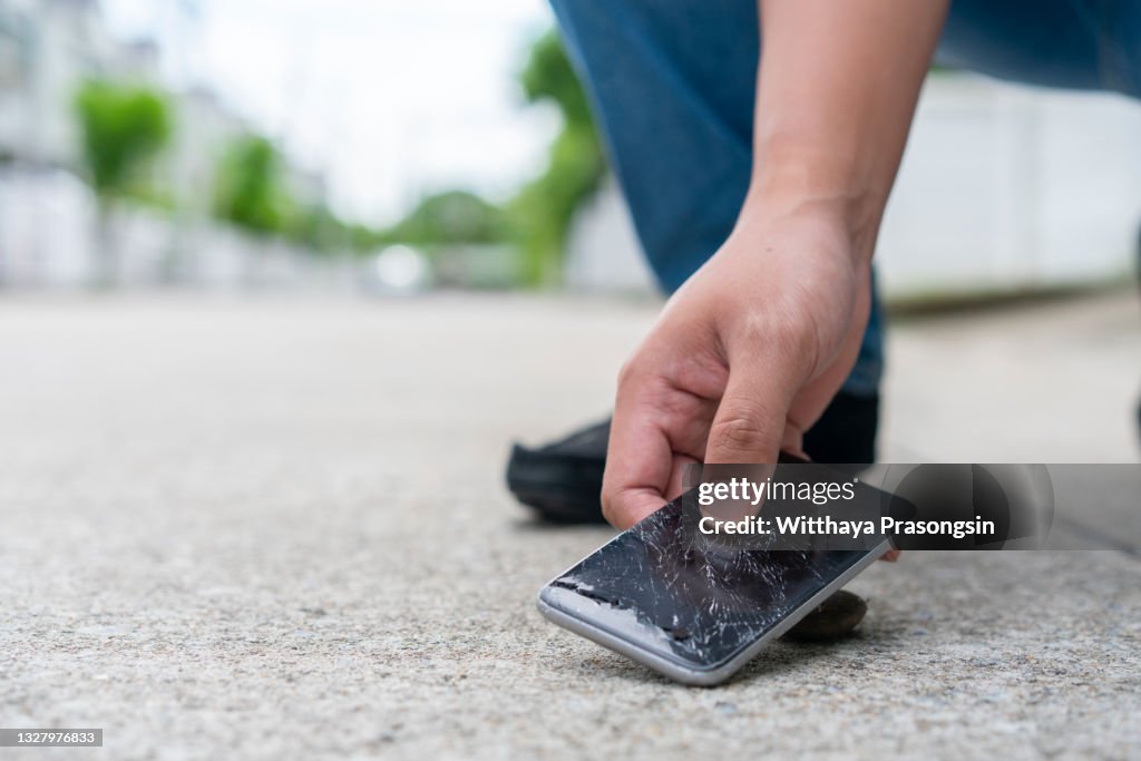 Damaged mobile phone with cracked touch screen.