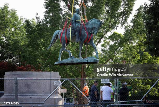 Workers remove a statue of Confederate General Robert E. Lee from Market Street Park July 10, 2021 in Charlottesville, Virginia. Initial plans to...