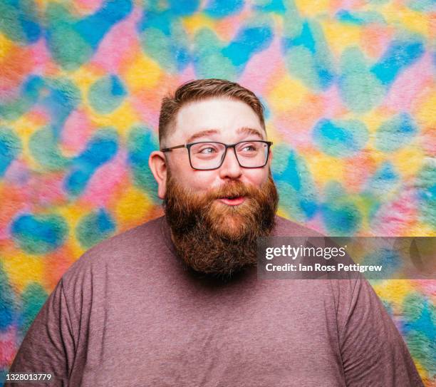 chubby, bearded man on multi-coloured background - anticipation face stock pictures, royalty-free photos & images