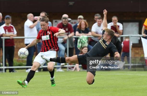 Liam Roche of Sileby Rangers clears the ball under pressure from Sam Hoskins of Northampton Town during the Pre-Season Friendly match between Sileby...