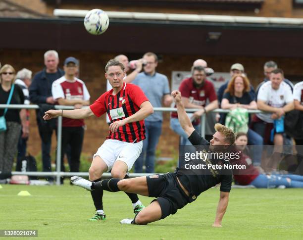 Liam Roche of Sileby Rangers clears the ball under pressure from Sam Hoskins of Northampton Town during the Pre-Season Friendly match between Sileby...