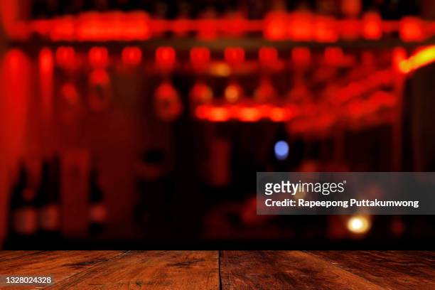 wooden table in front of abstract blurred background of resturant or cafe lights - bar counter stockfoto's en -beelden
