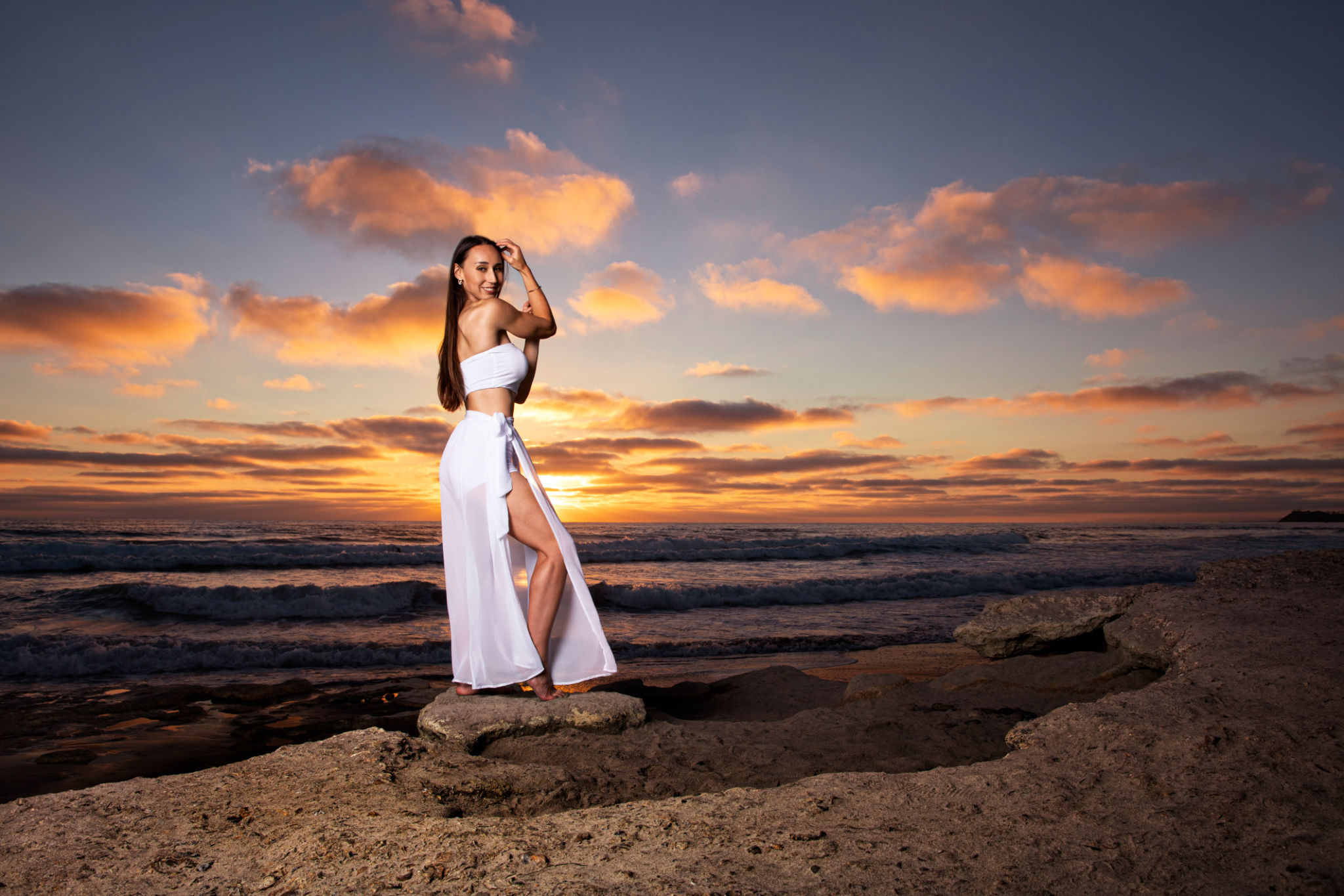 Beautiful brunette girl with long hair in white dress at sunset stock photo Beautiful brunette girl with long hair in white dress at sunset stock photo