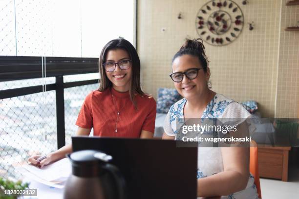 mother and daughter doing finances together at home - tuition stock pictures, royalty-free photos & images