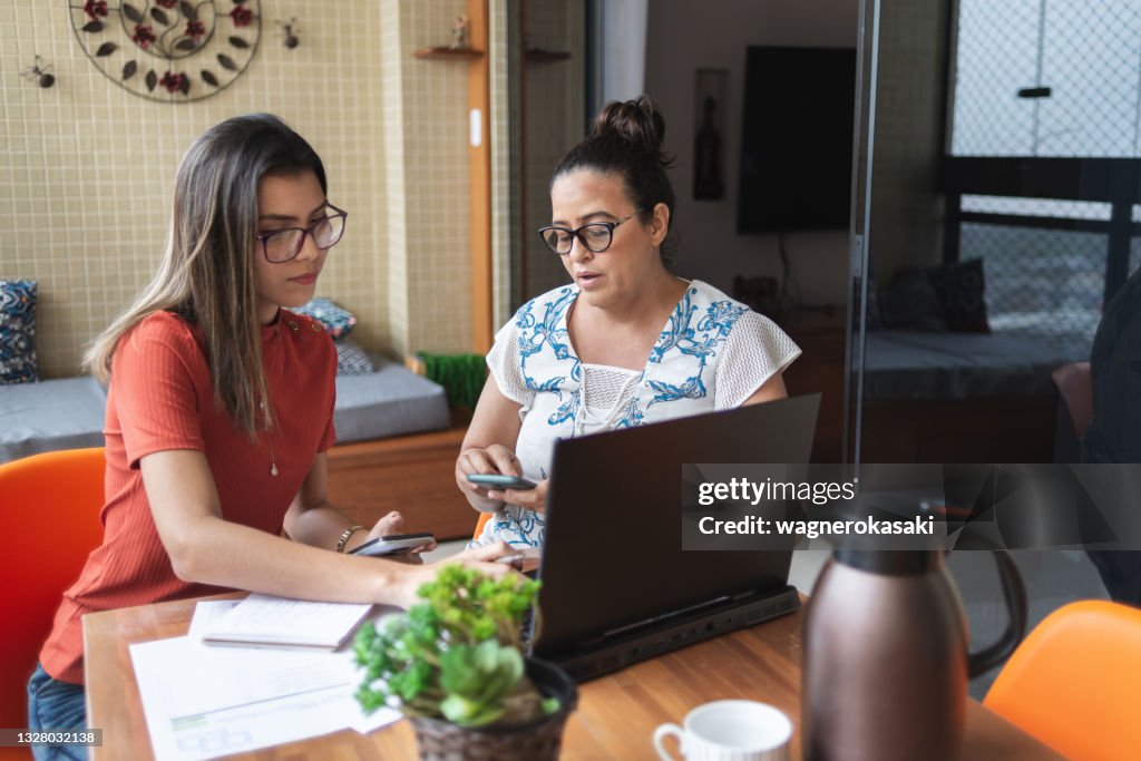 Mother and daughter doing finances together at home