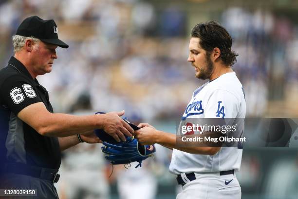 Umpire Ted Barrett checks the hat and glove of Trevor Bauer of the Los Angeles Dodgers for foreign substances after the first inning against the San...