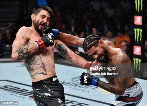 Carlos Condit and Max Griffin trade punches in their welterweight fight during the UFC 264 event at T-Mobile Arena on July 10, 2021 in Las Vegas,...