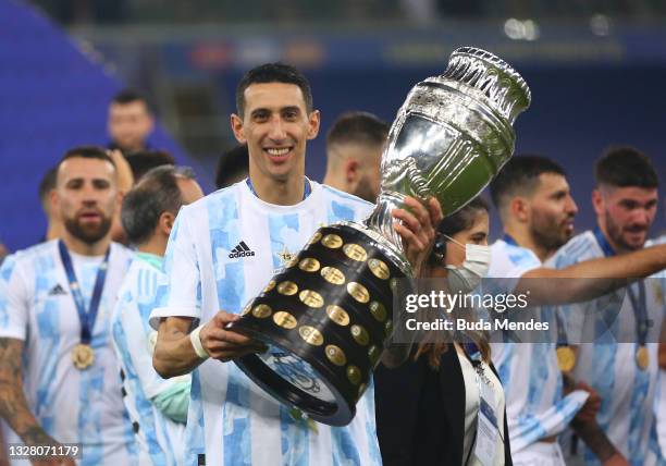 Angel Di Maria of Argentina poses with the trophy after winning the final of Copa America Brazil 2021 between Brazil and Argentina at Maracana...