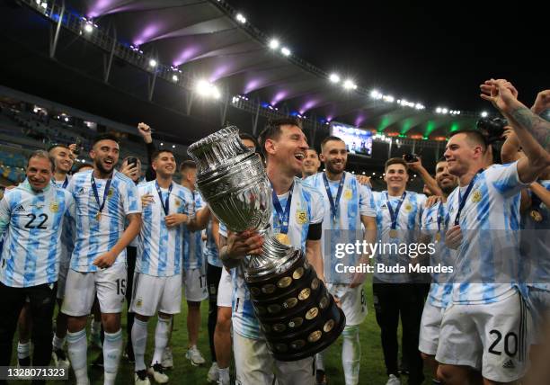 Lionel Messi of Argentina smiles with the trophy as he celebrates with teammates after winning the final of Copa America Brazil 2021 between Brazil...