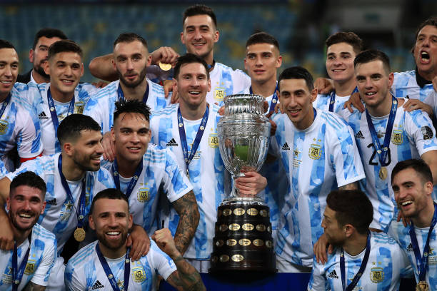 Lionel Messi and Angel Di Maria of Argentina along with teammates pose with the trophy after winning the final of Copa America Brazil 2021 between...