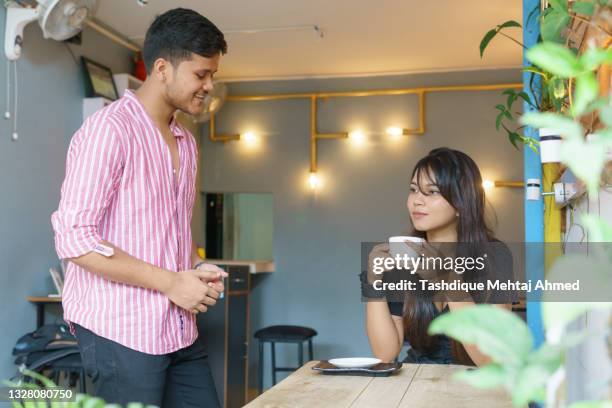 young indian male owner serving a customer of his cafeteria. - guwahati stock-fotos und bilder