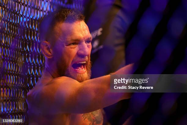 Conor McGregor of Ireland sits on the mat after injuring his ankle in the first round in his lightweight bout against Dustin Poirier during UFC 264:...