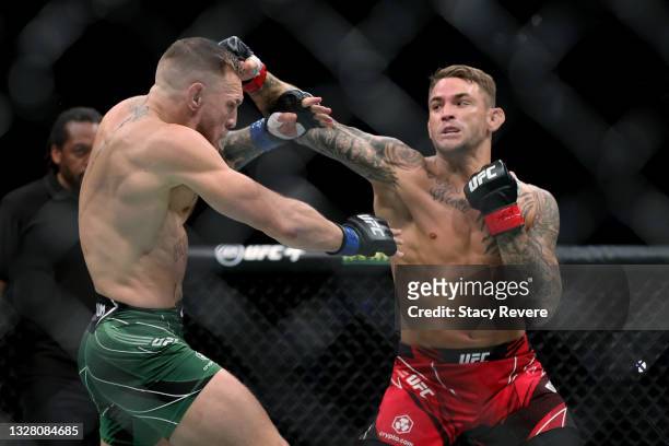 Dustin Poirier lands a punch on Conor McGregor of Ireland in the first round in their lightweight bout during UFC 264: Poirier v McGregor 3 at...