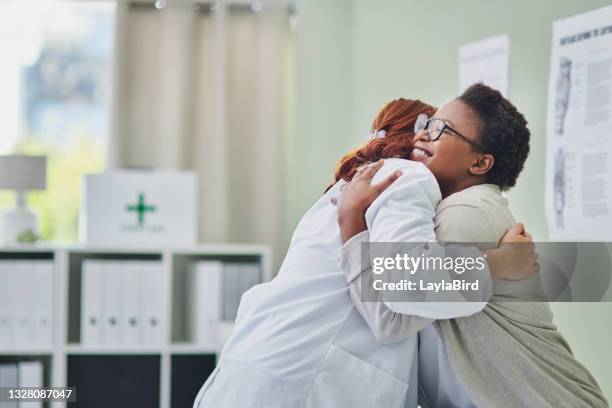 disparo de una joven abrazando a su médico durante una consulta - doctor and patient fotografías e imágenes de stock